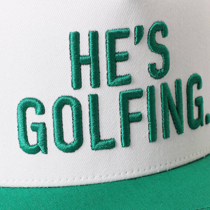 HE'S GOLFING Trucker Hat